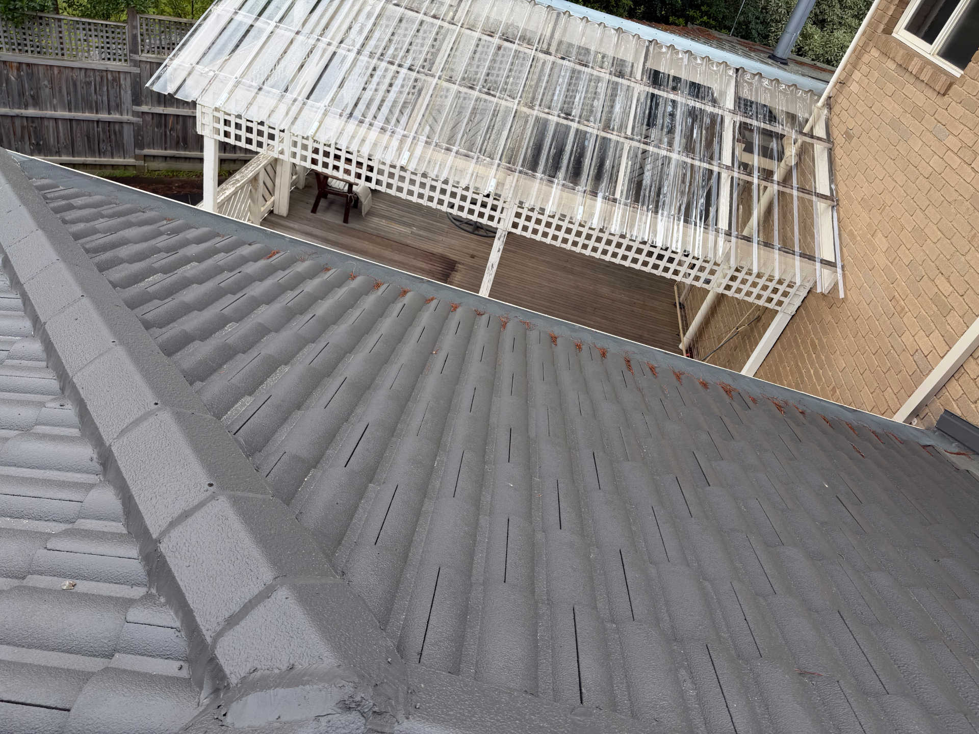 Cleaned tile roof and gutter line above a rear deck